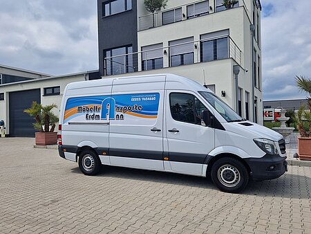 Ein weißer Sprinter. An der Seite des Fahrzeugs ist das Möbeltransport Erdmann Logo